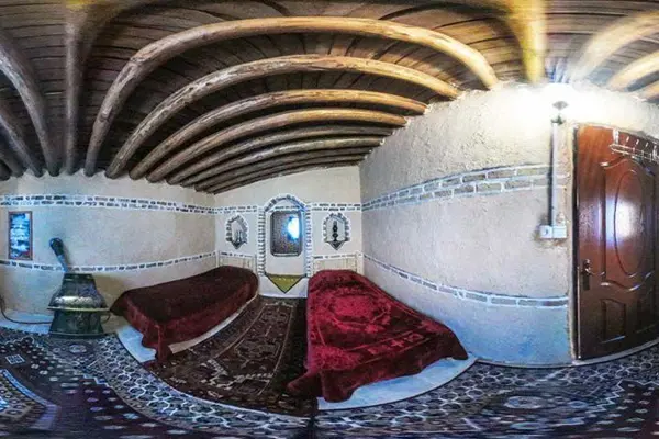 نمای داخلی و سنتی یک اقامتگاه بومگردی با دو تخت یک نفره و روتختی مخمل قرمز