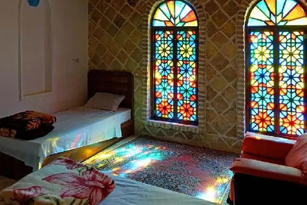اتاق یک اقامتگاه بومگردی با پنجره های رنگی به سبک خانه های یزد